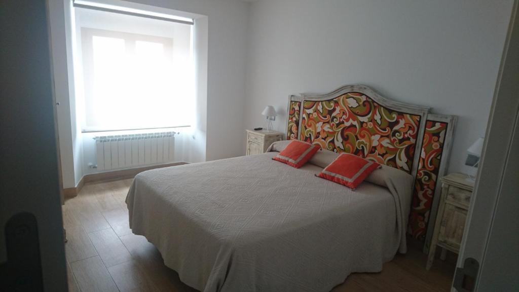 a bedroom with a bed with two red pillows on it at Almena de San Segundo in Ávila