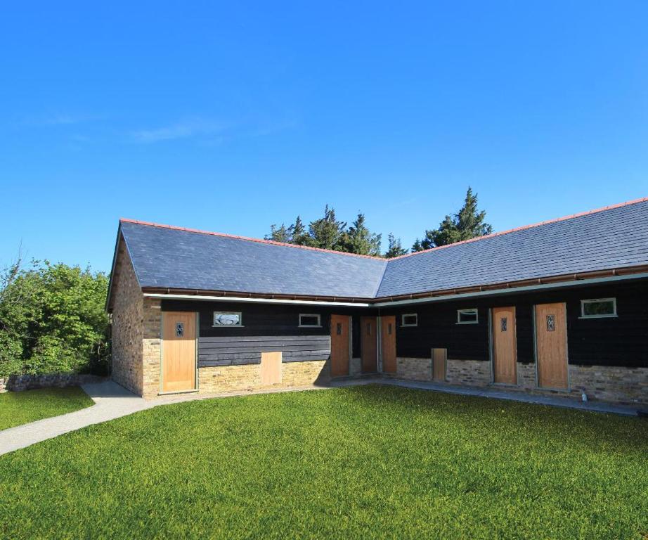 a barn with wooden doors and a grass yard at The Crown Lodges in Deal