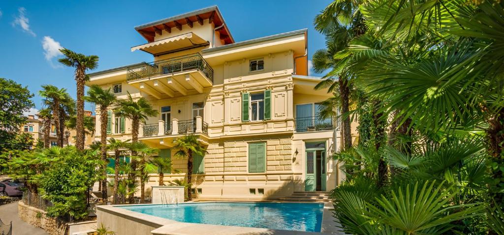 a house with a swimming pool in front of it at Villa Elizabeta Apartments in Opatija