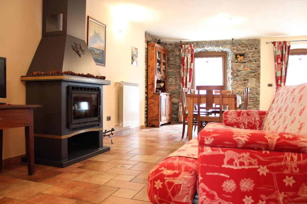 Una sala de estar con un sofá y una chimenea. en L'Atelier du Temps - Le Foyer du Cousin, en Nus