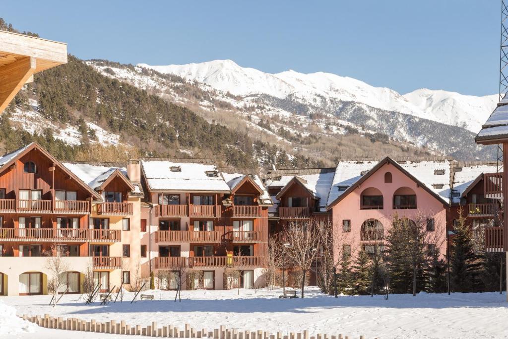 a resort in the snow with mountains in the background at Residence l'Alpaga - maeva Home in La Salle Les Alpes