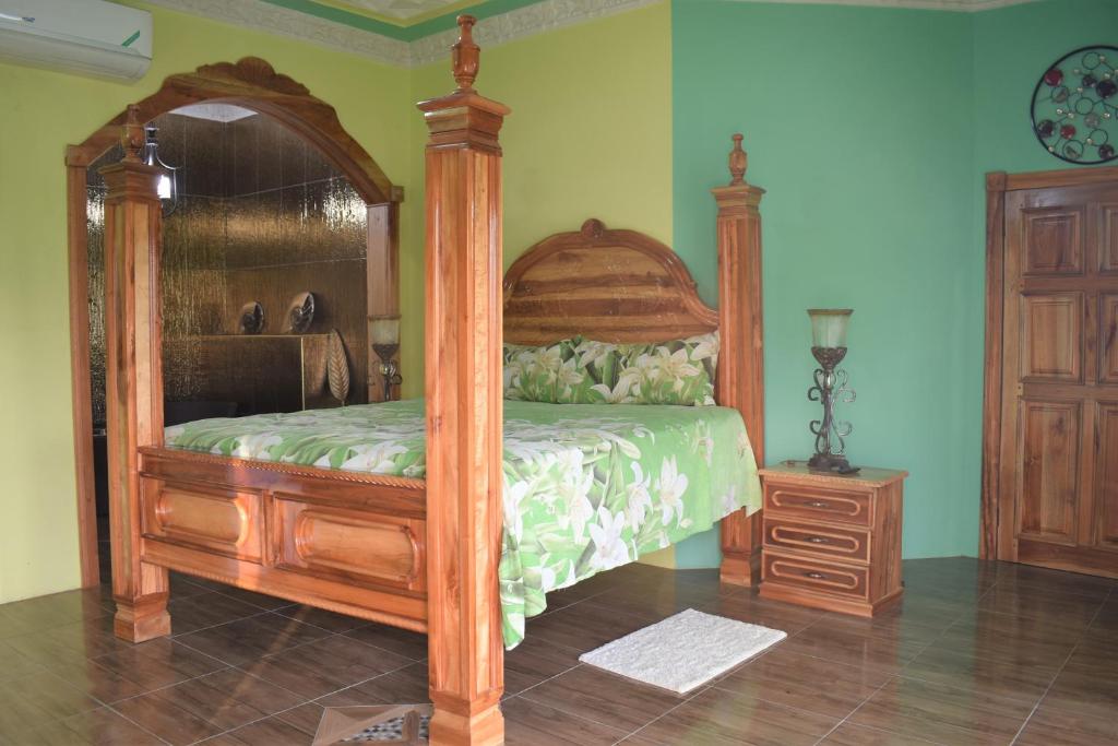 a bedroom with a wooden canopy bed and a dresser at Haven View Villa & Spa in Bluefields