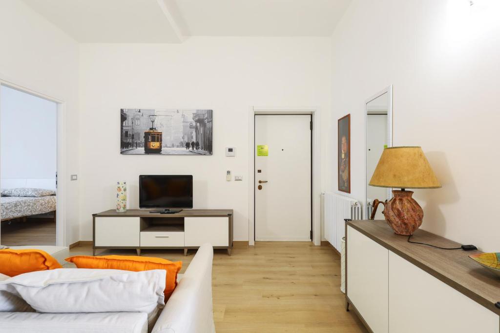 ein weißes Wohnzimmer mit einem Sofa und einem Tisch in der Unterkunft PrimoPiano - Sammartini in Mailand