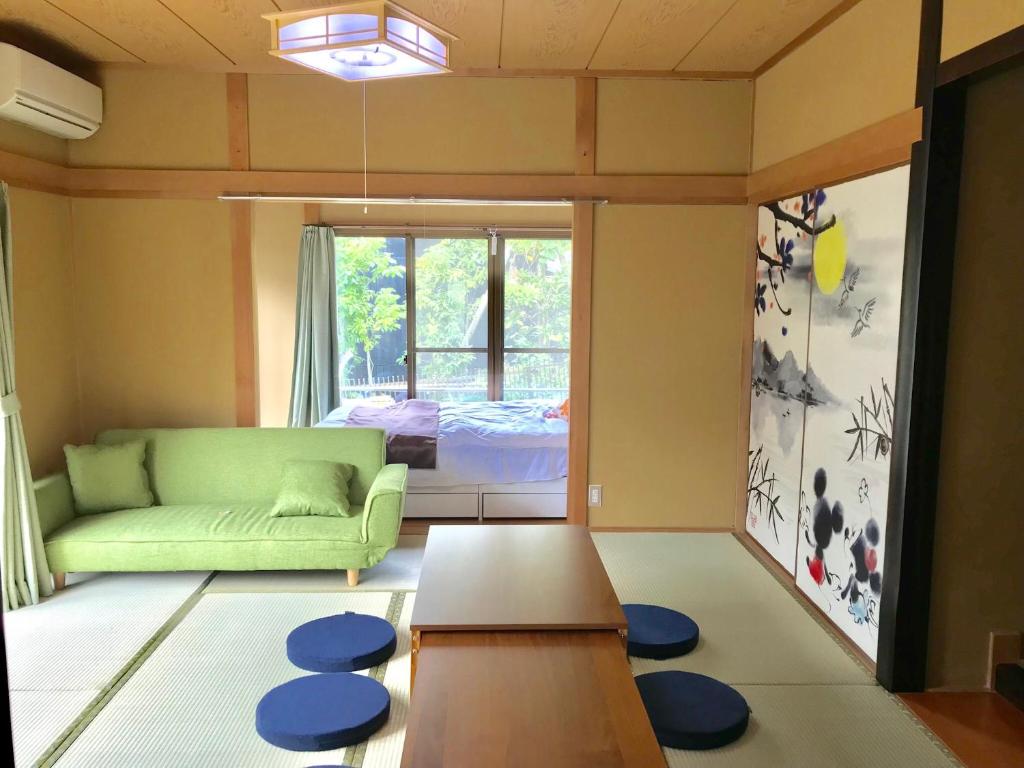 a living room with a green couch and a table at Yufu Inn in Yufuin