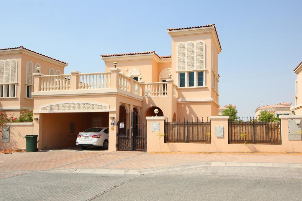 a house with a car parked in front of it at Piks Key JVC District16 Vibrant 2BR Villa wt GreenGarden in Dubai