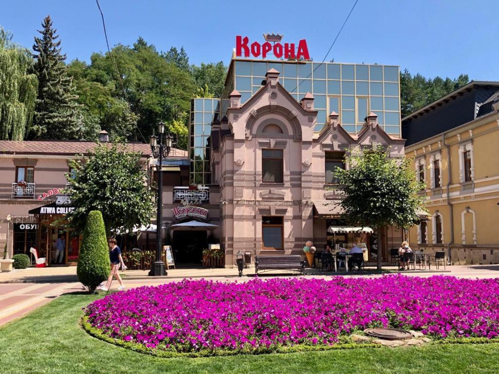 a building with purple flowers in a park at Korona Hotel in Kislovodsk