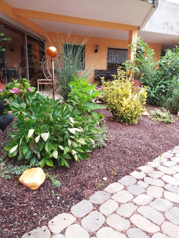 a garden with flowers and plants in front of a house at Ferienwohnung im Rottal in Oberrot