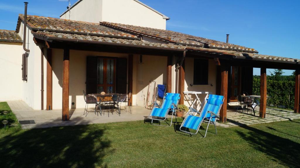 eine Terrasse mit blauen Stühlen und einem Tisch vor einem Haus in der Unterkunft Agriturismo Poggio San Pietro in Pitigliano