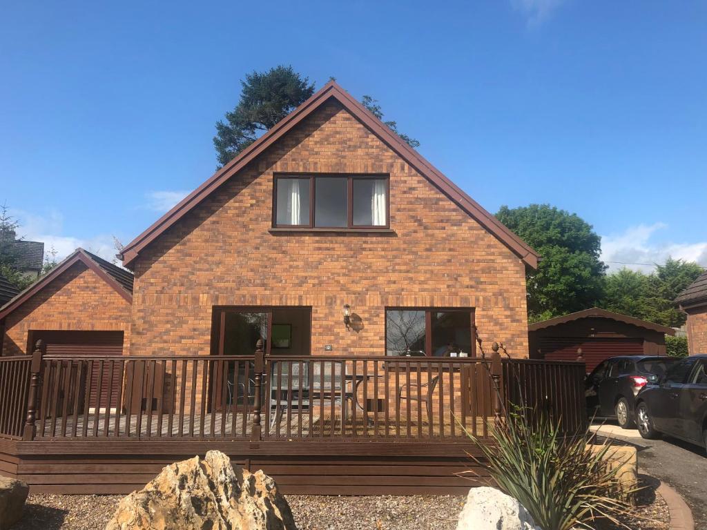 a brick house with a large deck in front of it at 12 Tullybay Drumcrow east with WIFI in Enniskillen