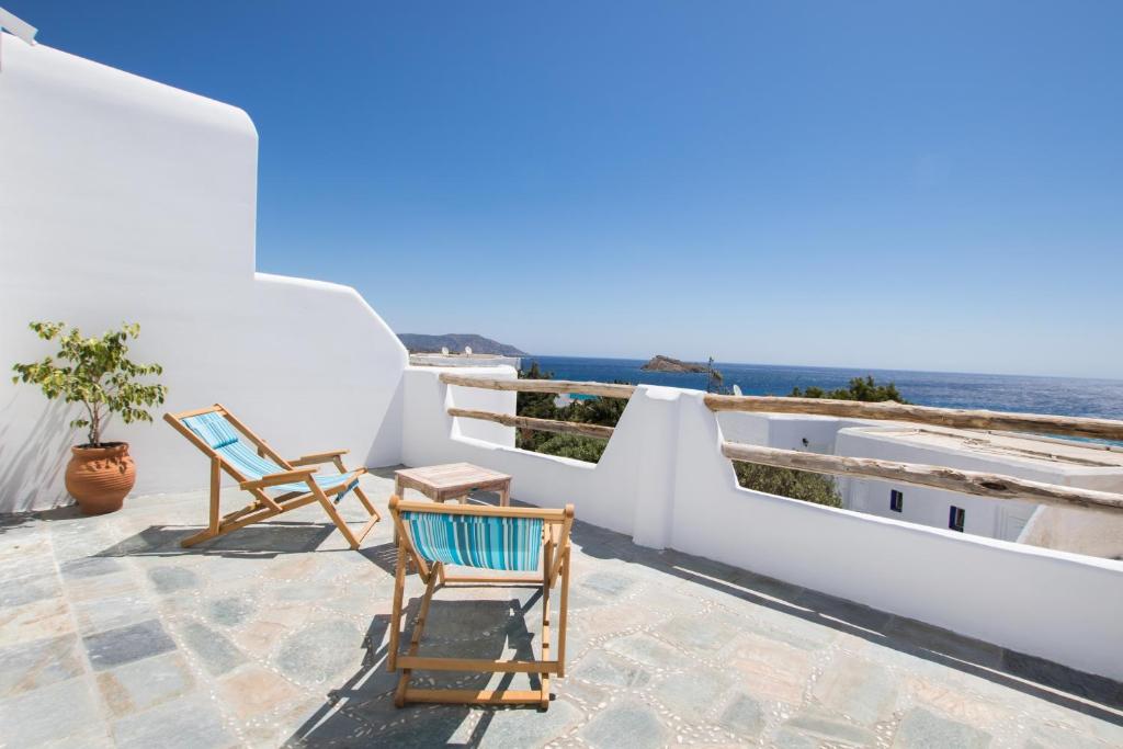 a pair of chairs on a patio overlooking the ocean at Poseidon Blue Gastronomy Hotel in Afiartis