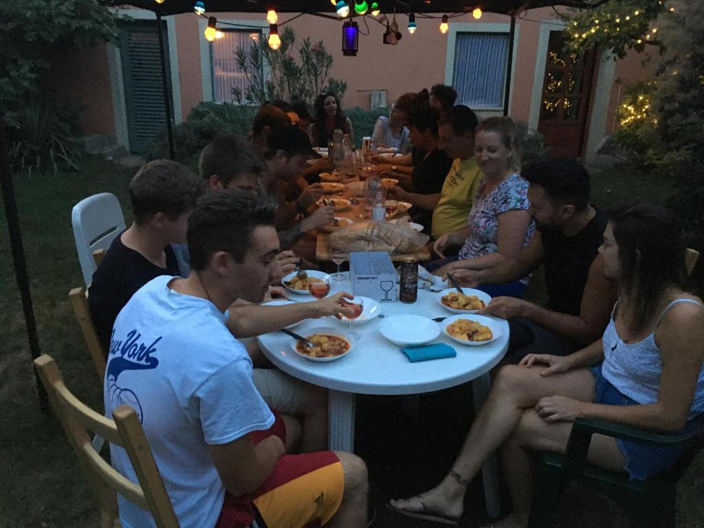 a group of people sitting around a table eating food at Balázs Guesthouse in Budapest