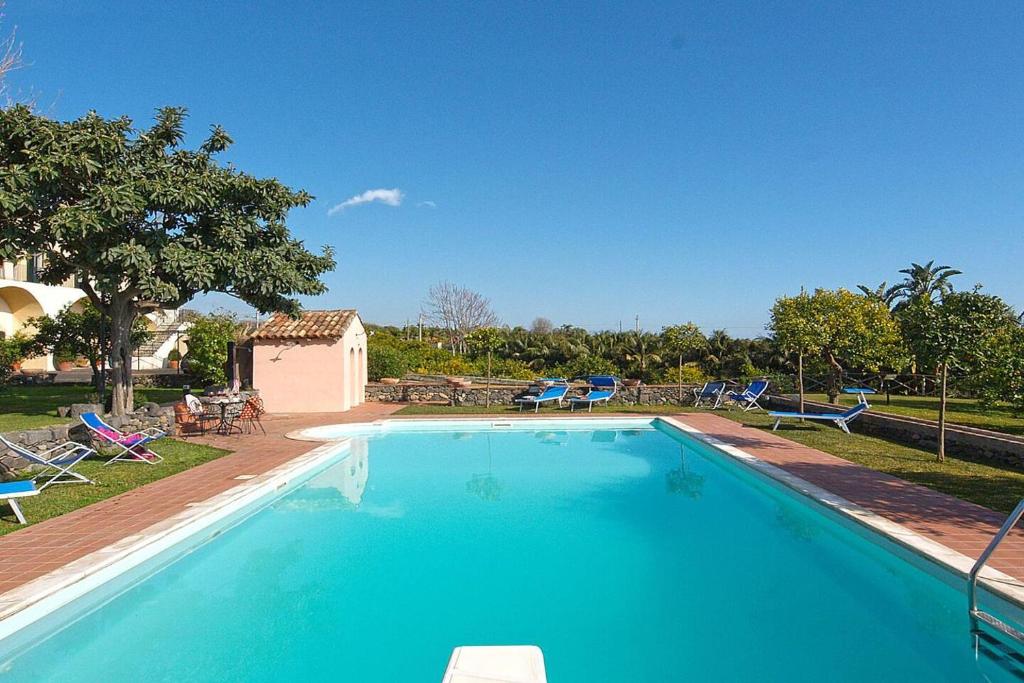 uma grande piscina com água azul num quintal em Villa Praiola - Exclusive seafacing mansion with pool and Jacuzzi em San Leonardello
