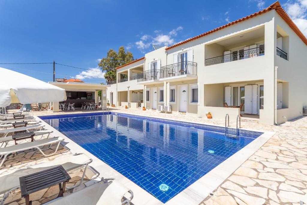 a swimming pool in front of a villa at Hotel Aphrodite in Stoupa