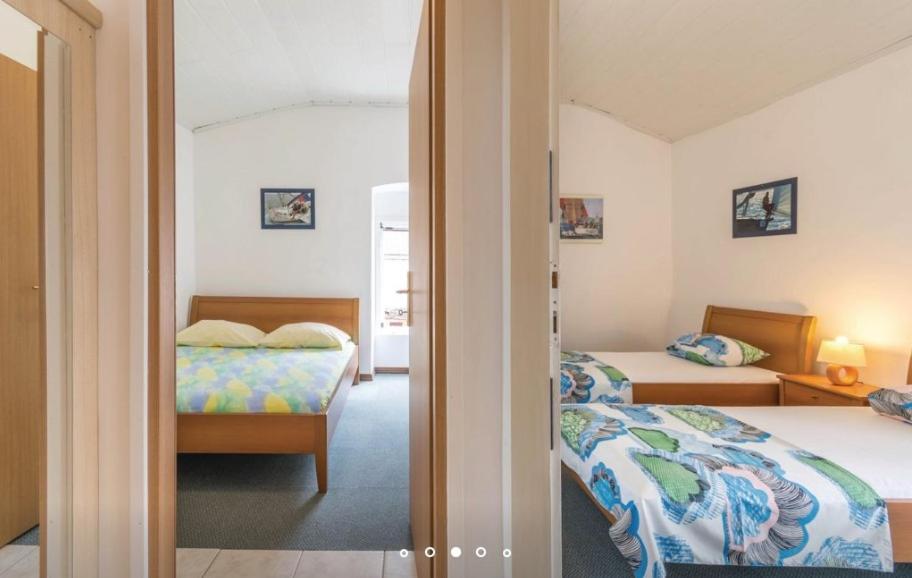 sypialnia z 2 łóżkami i drzwiami do pokoju w obiekcie House Hermes w mieście Pavicini