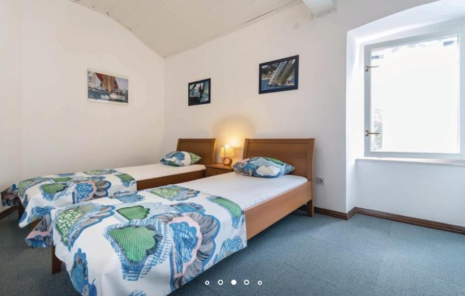 sypialnia z dwoma łóżkami i oknem w obiekcie House Hermes w mieście Pavicini