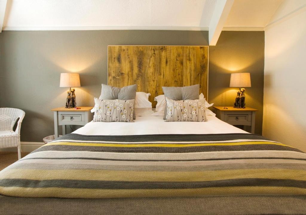 a bedroom with a large white bed with two lamps at Hunters Lodge Inn in Totnes