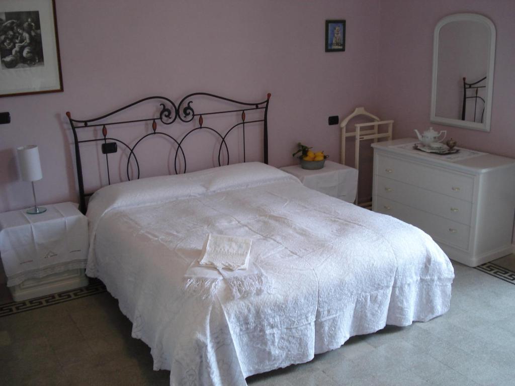 a bedroom with a large white bed and a dresser at Abruzzo Segreto in Navelli