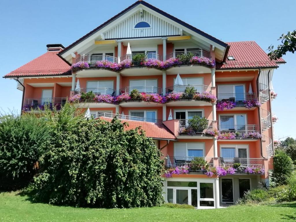 ein großes Gebäude mit Blumen auf den Balkonen in der Unterkunft Hotel-Restaurant Walserhof in Wasserburg