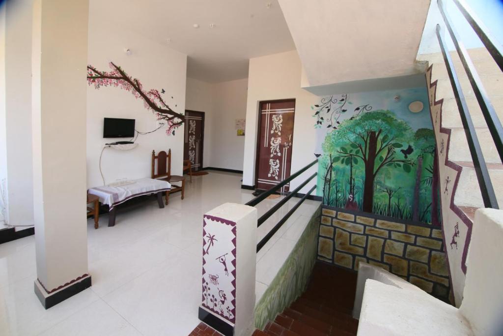 a room with a staircase with a painting on the wall at Tadoba Homestay Cottage in Chandrapur