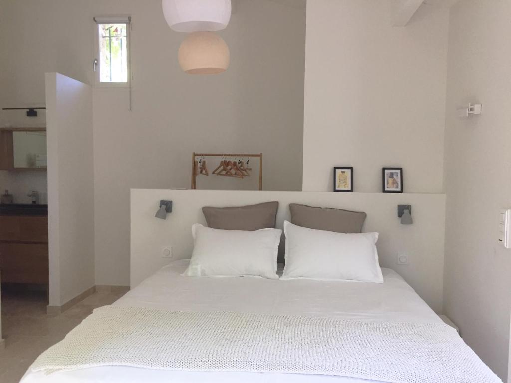 a white bed with two pillows in a bedroom at Serendip in Avignon