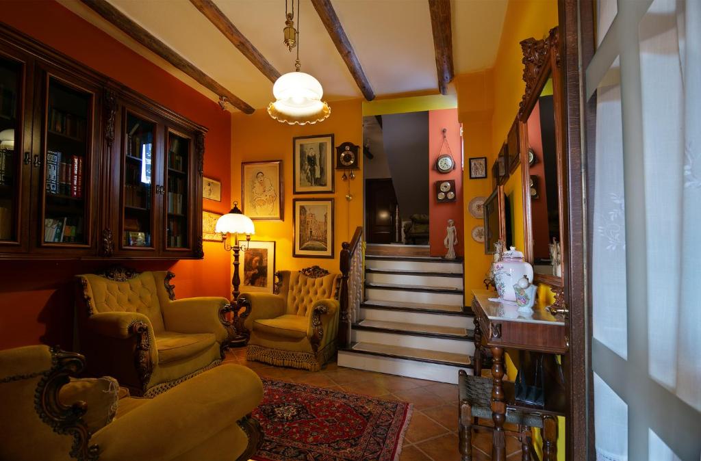 a living room with yellow walls and a staircase at Bujtina Sidheri in Korçë