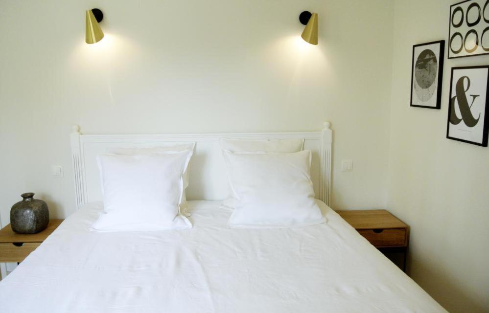 a bedroom with a white bed with two white pillows at Serendip in Avignon