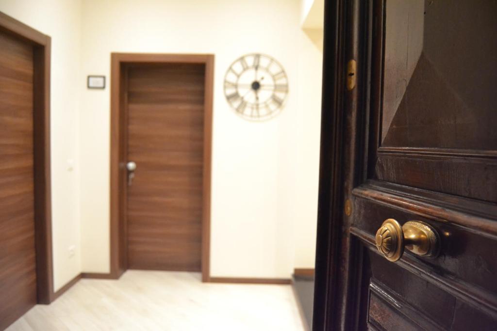 un pasillo con una puerta y un reloj en la pared en Palazzo Liberty BnB en Bolonia
