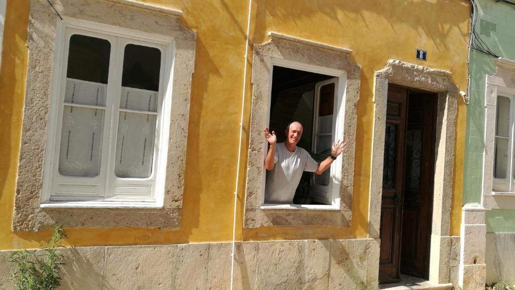 um homem parado numa janela de um edifício em Casa Magica em Olhão