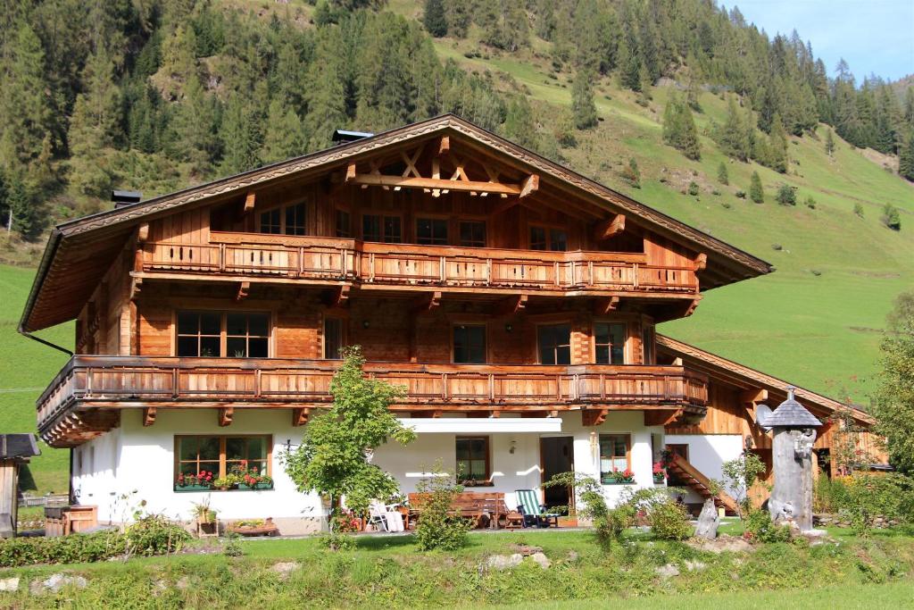 a large wooden house with a balcony at Ferienwohnung Rainer in Innervillgraten