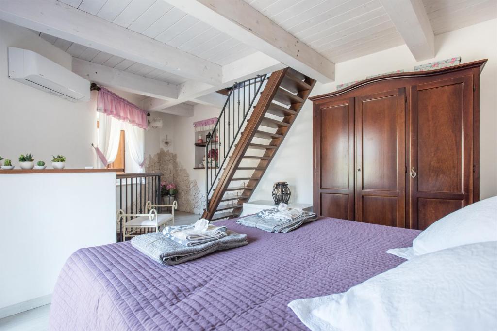 a bedroom with a purple bed and a staircase at Casa Francesca in Castiglione di Sicilia