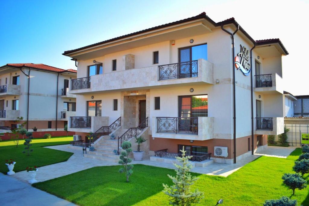 apartamentowiec z trawnikiem przed nim w obiekcie Valurile Mării Vama - Veche w mieście Vama Veche