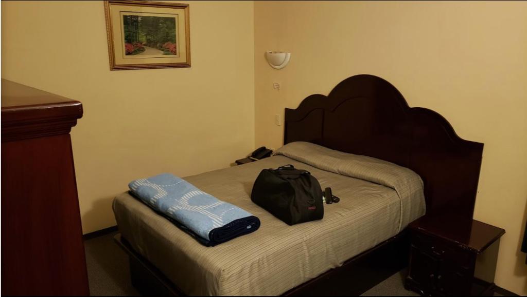 um quarto com uma cama com uma mochila em BONITTO INN® Mante em El Mante