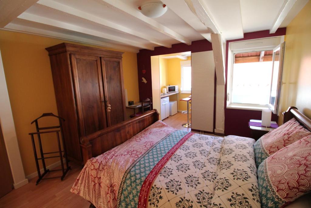 ein Schlafzimmer mit einem Bett mit einem Kopfteil aus Holz in der Unterkunft La chambre aux hirondelles in Ittenheim