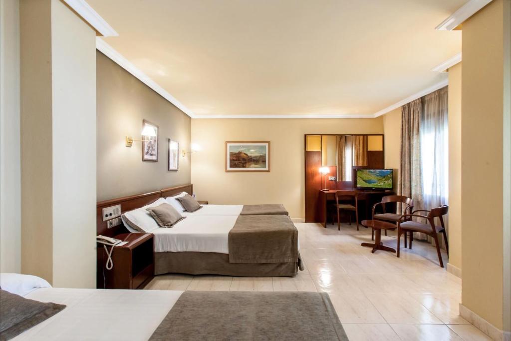 サン・ジュリア・デ・ロリアにあるYomo Imperialのベッドとデスクが備わるホテルルームです。