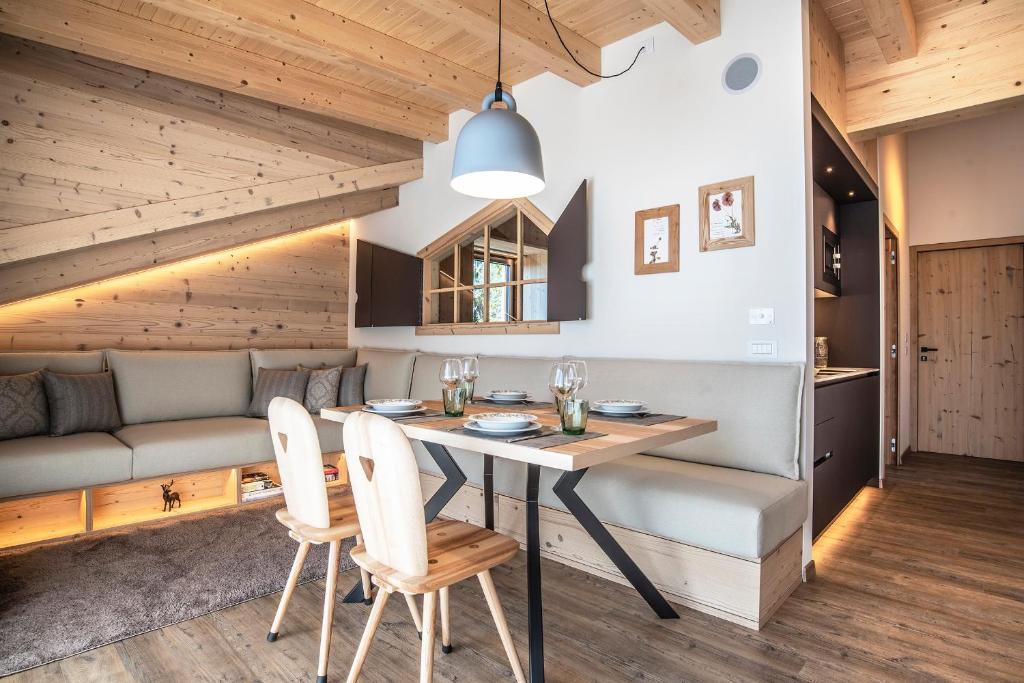 a kitchen and living room with a table and chairs at Montanara Chalet in Fai della Paganella