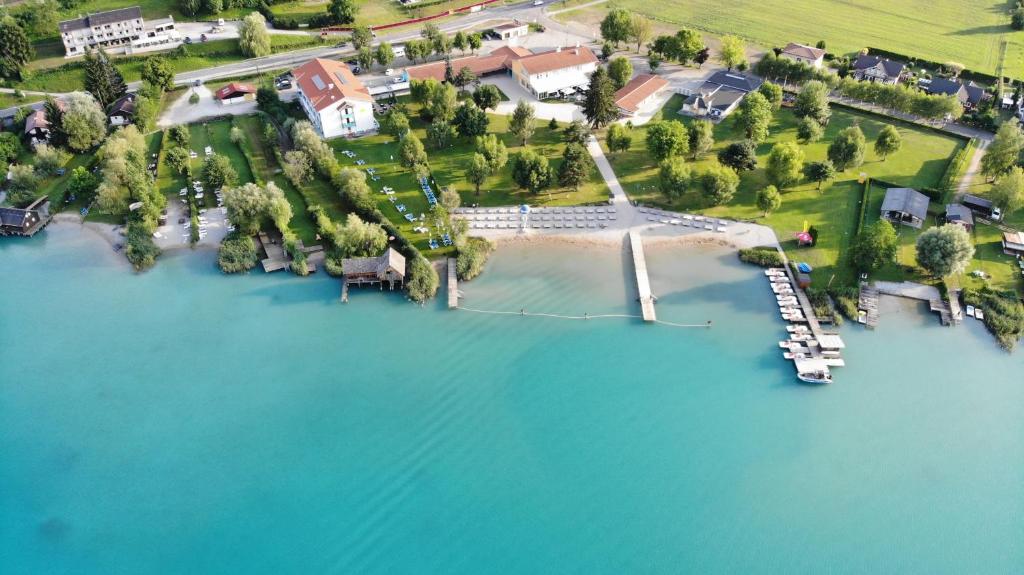 an aerial view of a house on a island in the water at Strandhotel Faak in Faak am See
