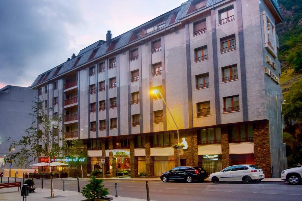un gran edificio con coches estacionados frente a él en Yomo Imperial, en Sant Julià de Lòria