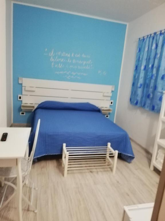 a bedroom with a bed and a blue wall at B&B Catanzaro lido La collina dei poeti in Catanzaro Lido