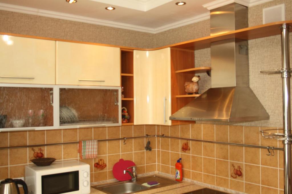 eine Küche mit Spüle und Mikrowelle in der Unterkunft Элитная Люкс квартира с видом на реку Иртыш! in Pawlodar