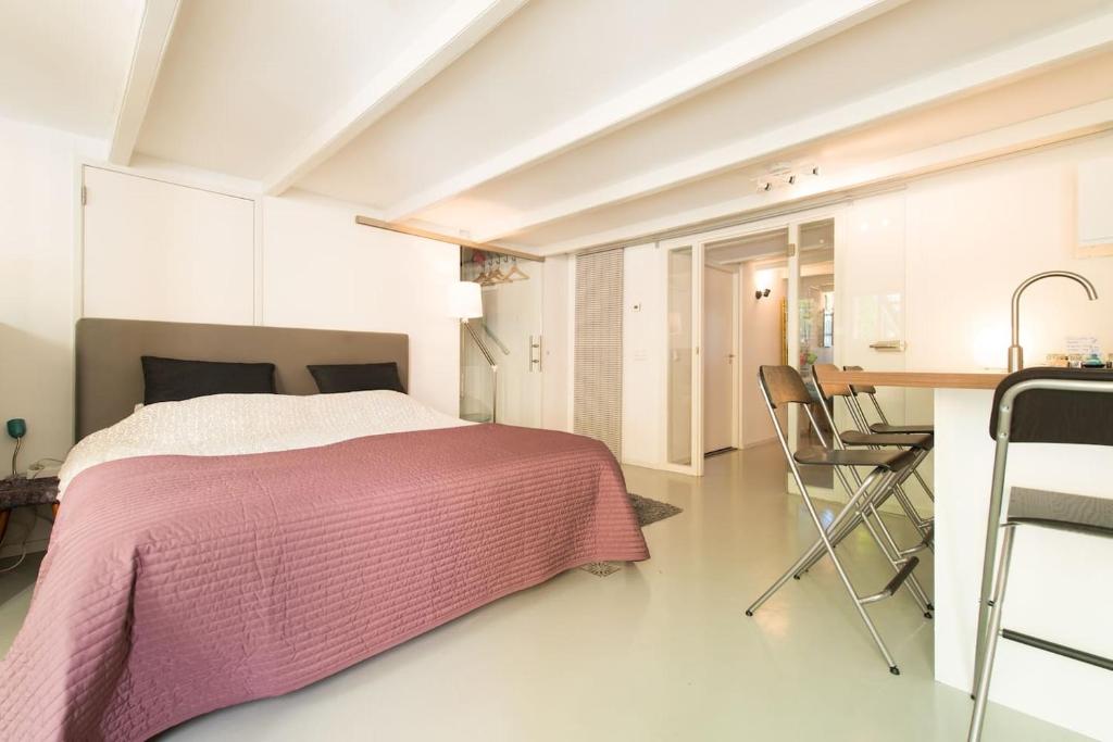 a bedroom with a bed and a table and chairs at Quiet apartment for 4 at park in center in Amsterdam