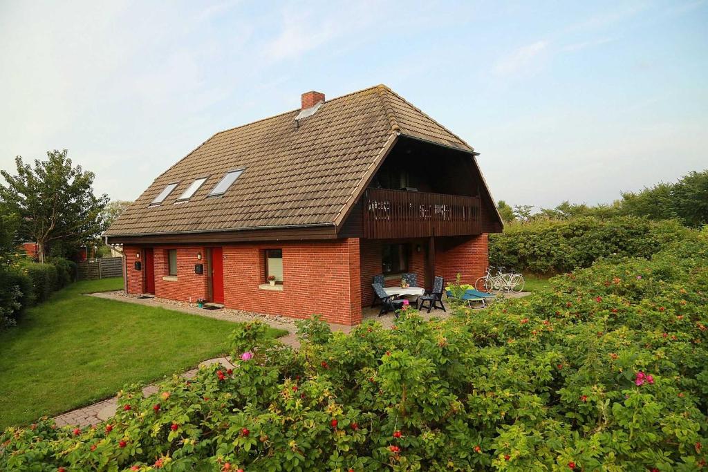 a small red brick house with a roof at Ferienwohnung MeinFriKo in Friedrichskoog-Spitze