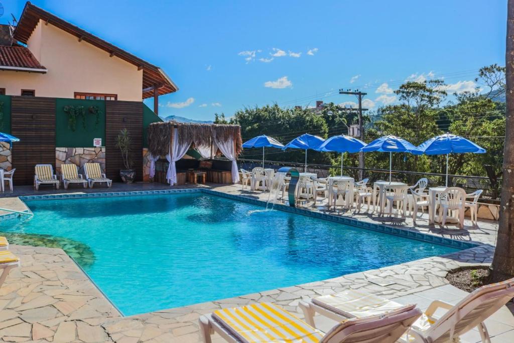 uma grande piscina com cadeiras e guarda-sóis em Termas Park Hotel em Gravatal