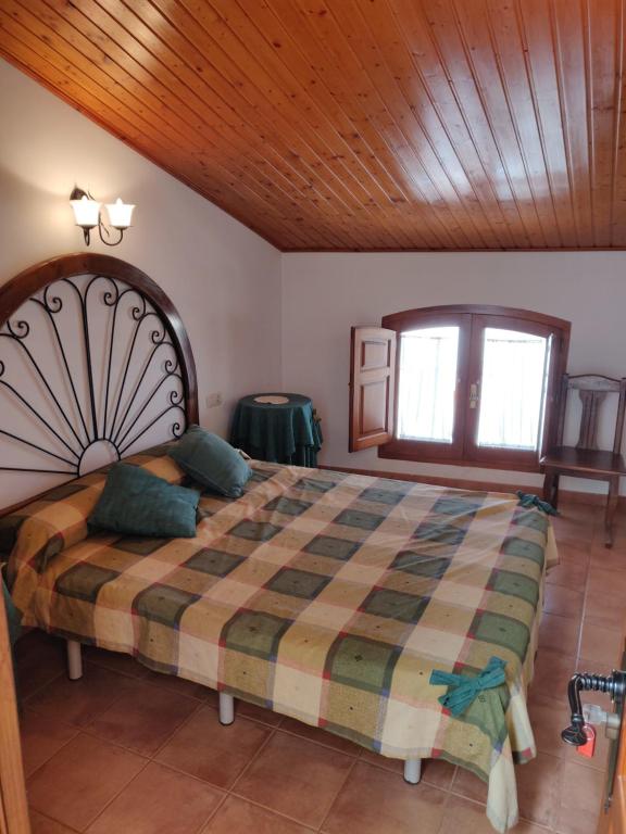 a bedroom with a large bed with a wooden ceiling at Casa Josefina in Yátova