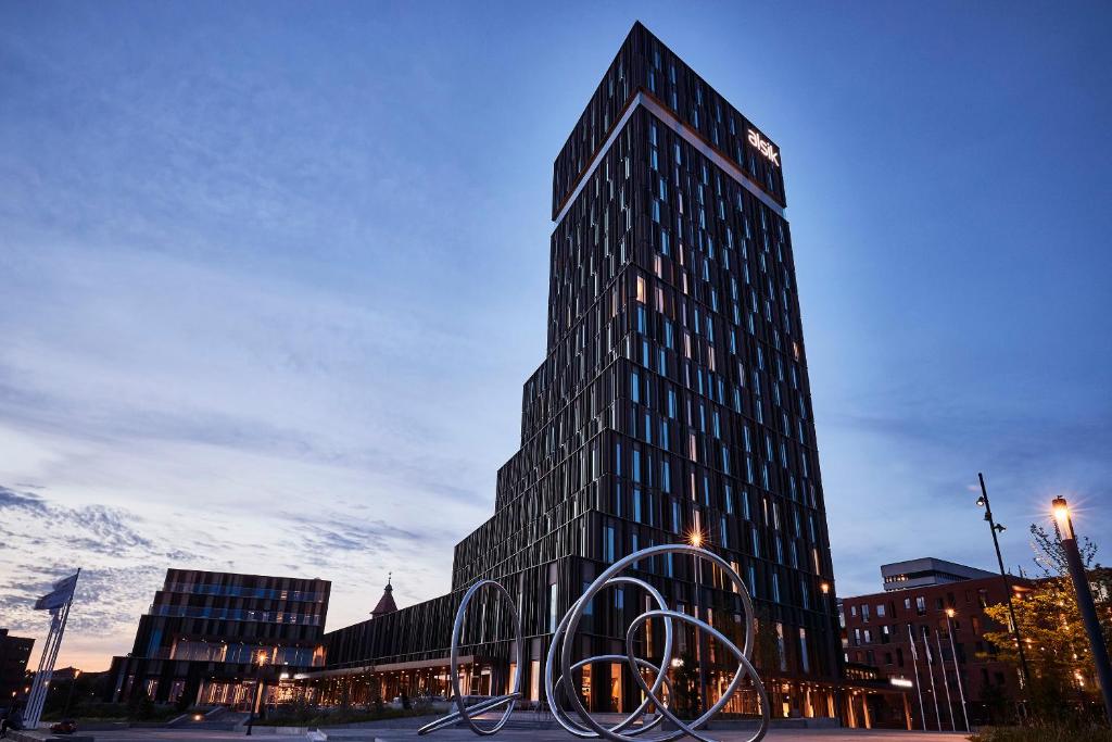 un edificio alto con una escultura delante en Steigenberger Alsik – Hotel & Spa en Sønderborg