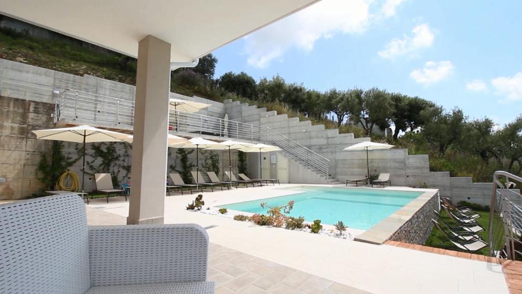 a swimming pool with chairs and umbrellas next to a building at Stella Marina Agropoli in Agropoli