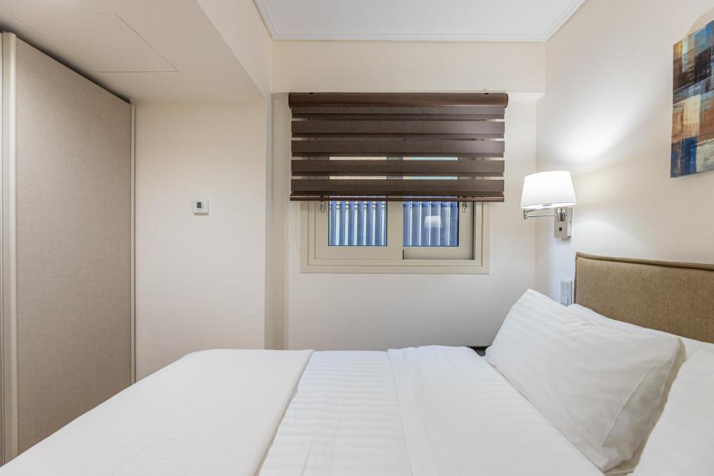 A bed or beds in a room at Olygreen Athens Residences