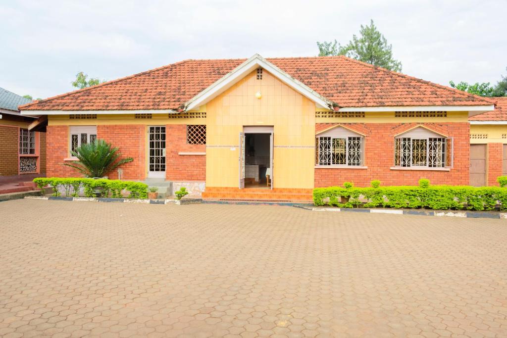 a brick house with a driveway in front of it at Palm Hotel in Mbale