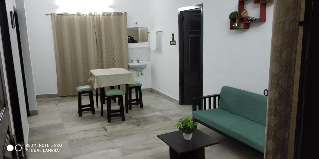 - un salon avec un canapé vert et une table dans l'établissement Andoor Homes, Apt No 2B, à Trivandrum