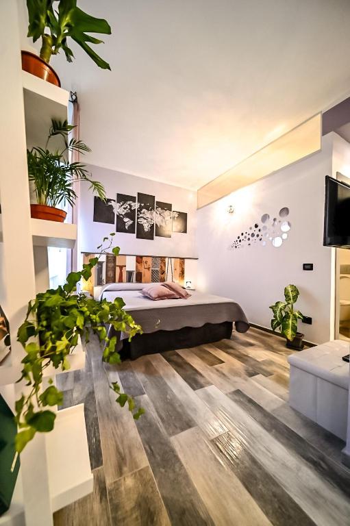 un dormitorio con una cama y macetas. en CIVICO 69 AFFITTACAMERE, en La Spezia