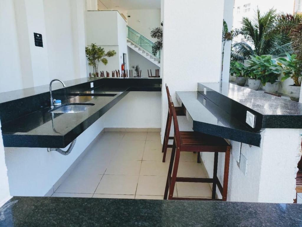 uma cozinha com um lavatório e um balcão com uma cadeira em Apartamento na Praia Grande - Ubatuba em Ubatuba